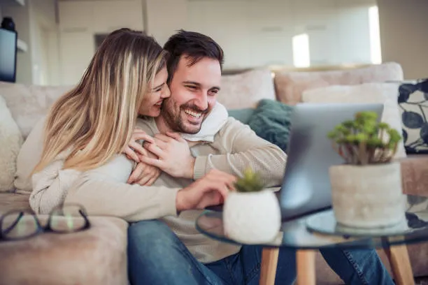  father and child looking at each other smiling while on laptop